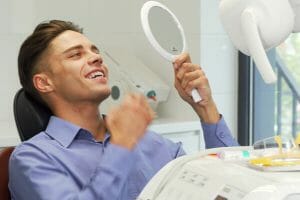 Handsome young man examining his teeth